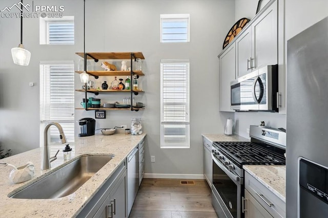 2454 Jazzy Lady Ct, Colorado Springs, CO 80922 - kitchen featuring stainless steel appliances, a sink, wood finished floors, gray cabinets, and baseboards