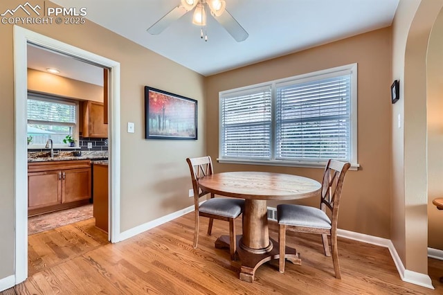 1609 Palmer Park Blvd, Colorado Springs, CO 80909 - dining space with light wood-style floors, baseboards, ceiling fan, and arched walkways