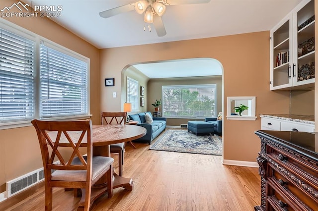 1609 Palmer Park Blvd, Colorado Springs, CO 80909 - dining room with arched walkways, a ceiling fan, light wood-style floors, and baseboards