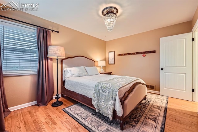 1609 Palmer Park Blvd, Colorado Springs, CO 80909 - bedroom with a chandelier, light wood-type flooring, and baseboards