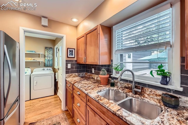 1609 Palmer Park Blvd, Colorado Springs, CO 80909 - kitchen featuring washing machine and clothes dryer, a sink, brown cabinets, freestanding refrigerator, and light wood finished floors