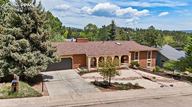 490 Wintery Cir, Colorado Springs, CO 80919 - view of front facade with a porch, concrete driveway, a garage, and a chimney