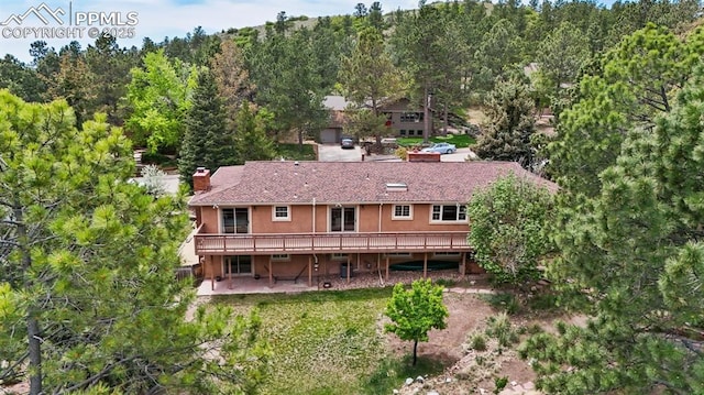 490 Wintery Cir, Colorado Springs, CO 80919 - back of property with a deck, a patio, a view of trees, and stucco siding