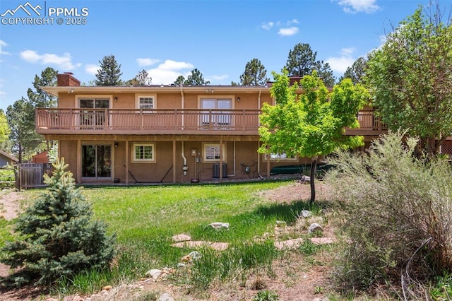 490 Wintery Cir, Colorado Springs, CO 80919 - back of property featuring stucco siding, a deck, a yard, a chimney, and central AC unit