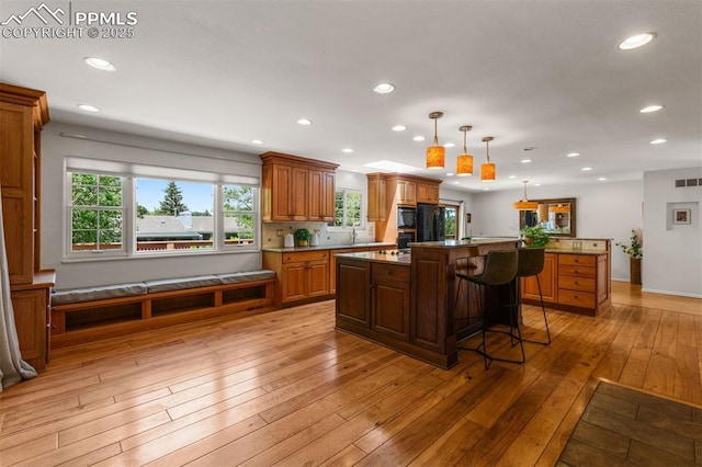 490 Wintery Cir, Colorado Springs, CO 80919 - kitchen featuring a kitchen island, recessed lighting, a breakfast bar, light wood finished floors, and pendant lighting