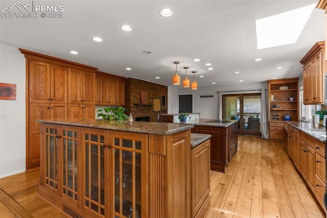 490 Wintery Cir, Colorado Springs, CO 80919 - kitchen featuring a large island, a skylight, brown cabinets, recessed lighting, and light wood finished floors