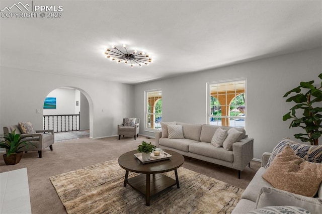 490 Wintery Cir, Colorado Springs, CO 80919 - living room featuring arched walkways, carpet floors, and baseboards