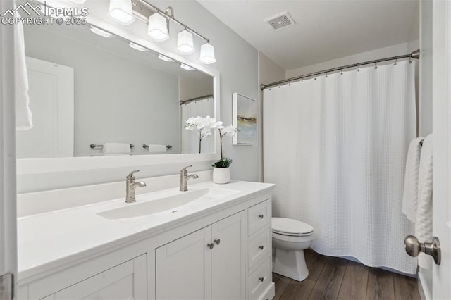9969 Bridgeport Dr, Colorado Springs, CO 80920 - bathroom featuring toilet, vanity, wood finished floors, and curtained shower