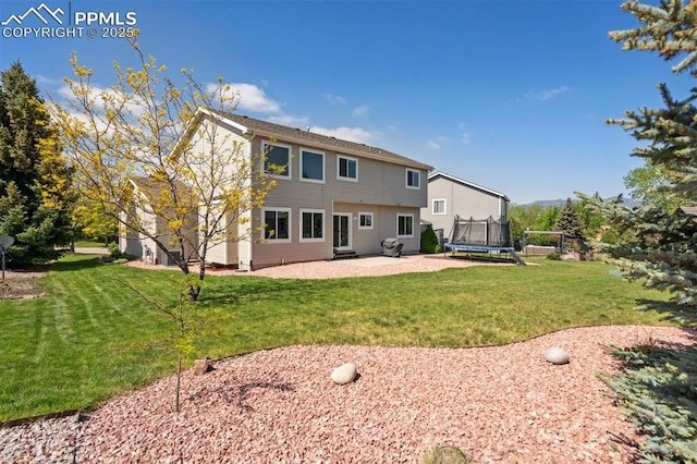 9969 Bridgeport Dr, Colorado Springs, CO 80920 - back of property with a trampoline, a patio, and a lawn