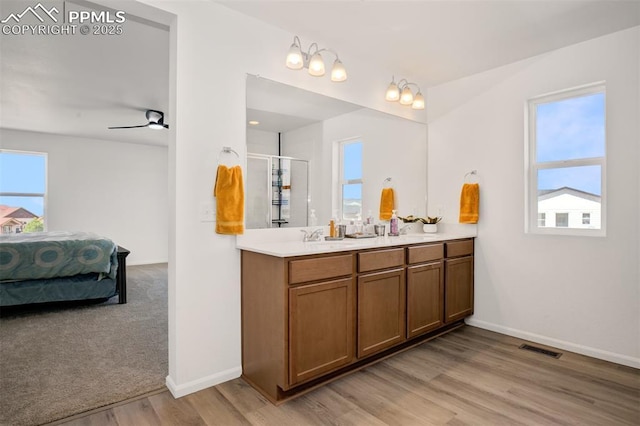 10046 Keating Dr, Peyton, CO 80831 - full bathroom with double vanity, wood finished floors, ensuite bath, a shower stall, and baseboards
