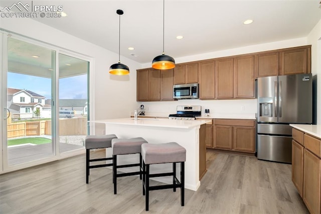 10046 Keating Dr, Peyton, CO 80831 - kitchen with appliances with stainless steel finishes, light wood-type flooring, brown cabinets, hanging light fixtures, and recessed lighting