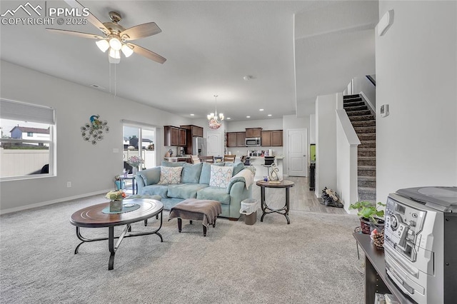 living area with a ceiling fan, light carpet, stairs, a chandelier, and recessed lighting