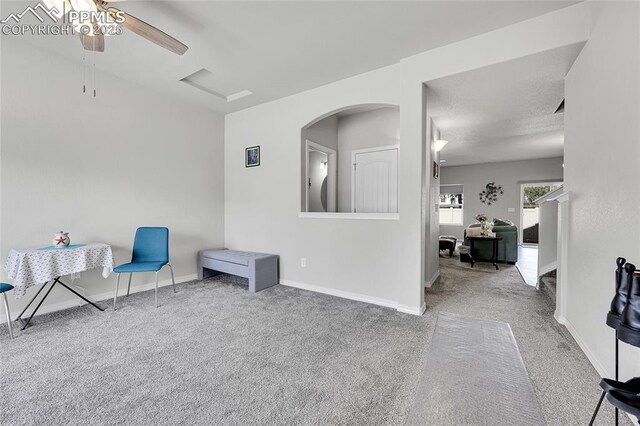 unfurnished room featuring carpet, ceiling fan, arched walkways, and baseboards