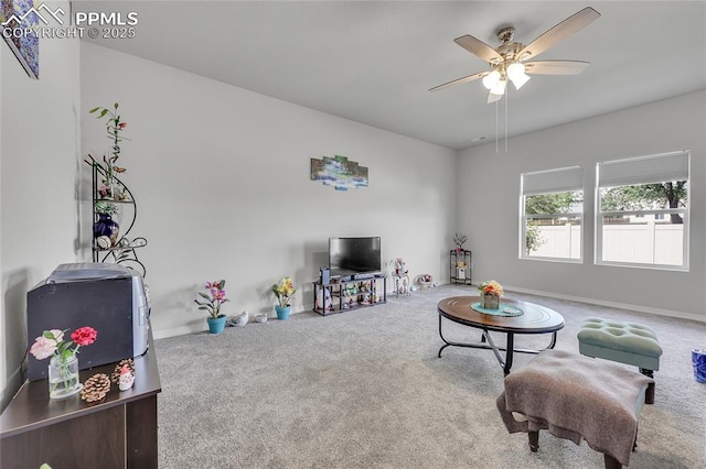 living area featuring carpet, ceiling fan, and baseboards