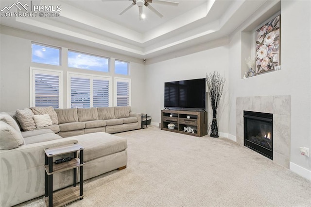 5799 Adkisson Pl, Colorado Springs, CO 80924 - carpeted living area featuring a raised ceiling, ceiling fan, baseboards, and a tile fireplace