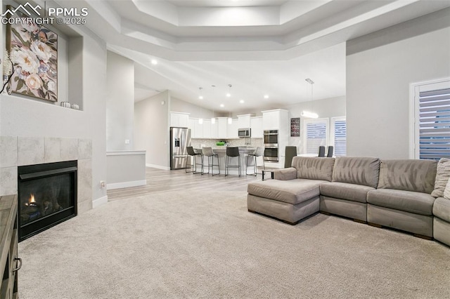 5799 Adkisson Pl, Colorado Springs, CO 80924 - living area with light carpet, recessed lighting, a tray ceiling, a tile fireplace, and baseboards