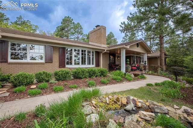 24 Upland Rd, Colorado Springs, CO 80906 - view of front of house featuring a chimney and brick siding