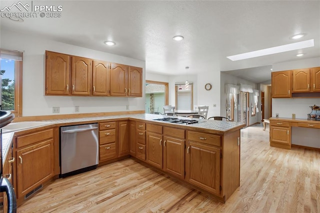 390 E Stirrup Trl, Monument, CO 80132 - kitchen with stainless steel appliances, a peninsula, light wood-type flooring, light countertops, and recessed lighting