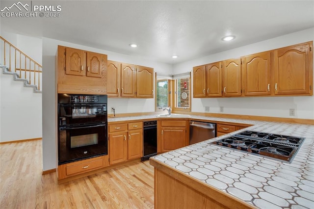 390 E Stirrup Trl, Monument, CO 80132 - kitchen featuring black appliances, light wood-style flooring, a sink, recessed lighting, and brown cabinets