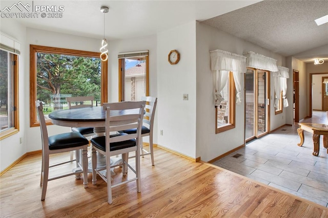 390 E Stirrup Trl, Monument, CO 80132 - dining room with light wood-style flooring, baseboards, and a textured ceiling