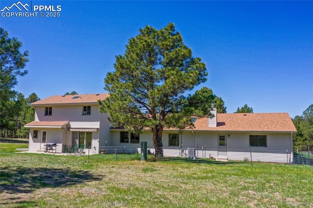 390 E Stirrup Trl, Monument, CO 80132 - back of house featuring a patio area, a lawn, and a chimney