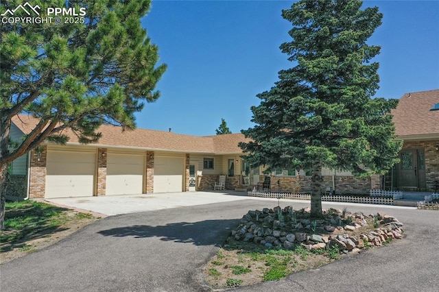 390 E Stirrup Trl, Monument, CO 80132 - view of front of property with an attached garage, brick siding, and driveway