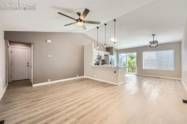6491 Ferndale Dr, Colorado Springs, CO 80923 - unfurnished living room with vaulted ceiling, light wood finished floors, ceiling fan, baseboards, and a sink