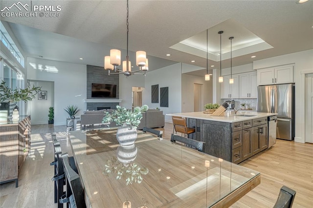 9473 Bugaboo Dr, Colorado Springs, CO 80924 - dining room featuring baseboards, light wood-type flooring, a chandelier, a tray ceiling, and recessed lighting