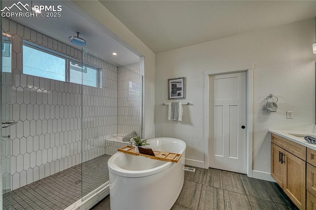 9473 Bugaboo Dr, Colorado Springs, CO 80924 - bathroom with a stall shower, a soaking tub, vanity, and baseboards