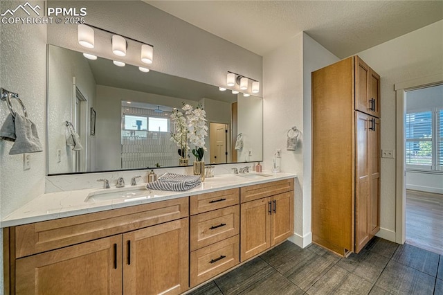 9473 Bugaboo Dr, Colorado Springs, CO 80924 - bathroom with a textured wall, double vanity, and baseboards