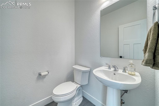 9473 Bugaboo Dr, Colorado Springs, CO 80924 - bathroom with toilet, baseboards, and a textured wall