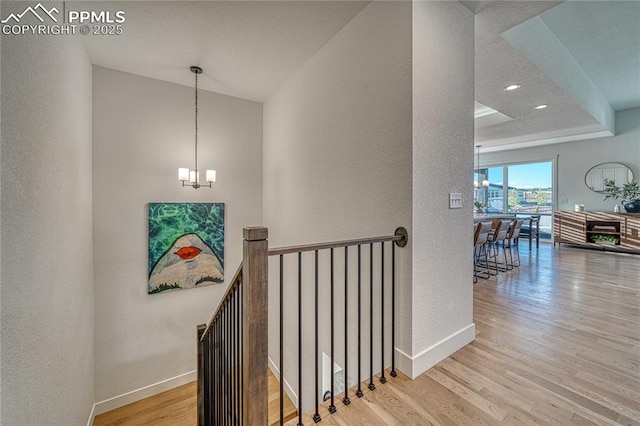 9473 Bugaboo Dr, Colorado Springs, CO 80924 - staircase with wood finished floors, a textured wall, baseboards, a chandelier, and recessed lighting