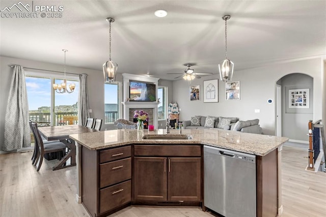 12879 Morning Creek Ln, Peyton, CO 80831 - kitchen featuring stainless steel dishwasher, open floor plan, a sink, arched walkways, and a ceiling fan