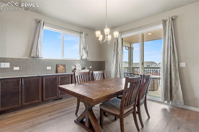 12879 Morning Creek Ln, Peyton, CO 80831 - dining room with light wood-type flooring and a chandelier