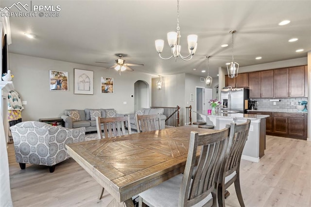 12879 Morning Creek Ln, Peyton, CO 80831 - dining space with arched walkways, recessed lighting, light wood-type flooring, a chandelier, and ceiling fan