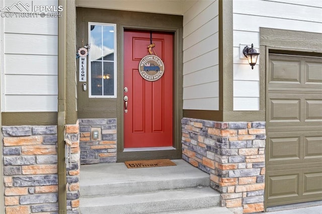 12879 Morning Creek Ln, Peyton, CO 80831 - view of exterior entry featuring stone siding and a garage