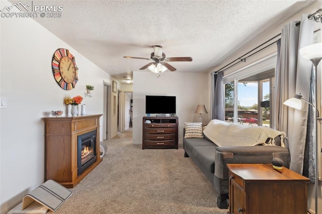 1409 Evergreen Dr, Colorado Springs, CO 80911 - living room featuring carpet, a textured ceiling, ceiling fan, and a glass covered fireplace