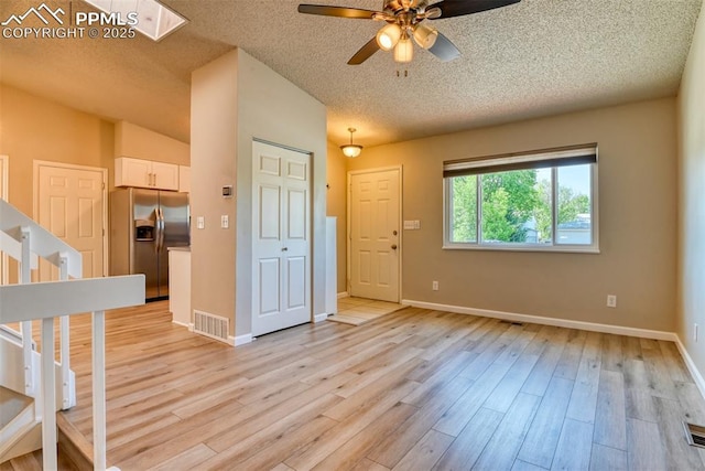 4472 Eastcrest Cir, Colorado Springs, CO 80916 - foyer with ceiling fan, a textured ceiling, stairs, and light wood-type flooring