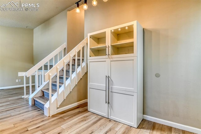 4472 Eastcrest Cir, Colorado Springs, CO 80916 - staircase featuring wood finished floors, baseboards, and a textured ceiling
