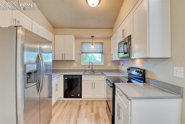 4472 Eastcrest Cir, Colorado Springs, CO 80916 - kitchen with black appliances, a sink, light wood-style flooring, a textured ceiling, and white cabinets