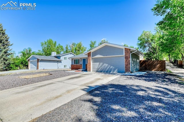 4472 Eastcrest Cir, Colorado Springs, CO 80916 - view of front of home with brick siding, an attached garage, and driveway