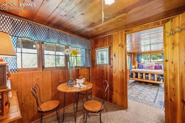 3875 Overlook Rd, Colorado Springs, CO 80906 - carpeted dining space with wood ceiling, wood walls, and healthy amount of natural light
