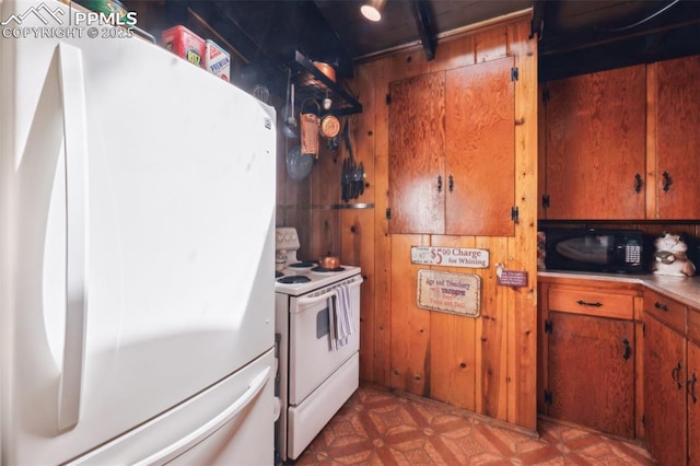 3875 Overlook Rd, Colorado Springs, CO 80906 - kitchen with white appliances, wood walls, brown cabinets, and tile patterned floors