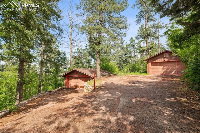 3875 Overlook Rd, Colorado Springs, CO 80906 - view of yard with driveway, an outdoor structure, and a garage