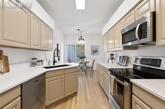 4430 Songglen Cir, Colorado Springs, CO 80906 - kitchen featuring appliances with stainless steel finishes, a sink, light wood-type flooring, and light countertops