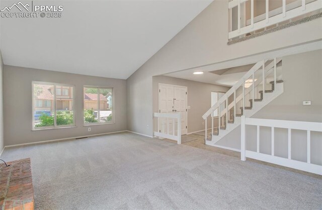 3177 Blue Mountain Way, Colorado Springs, CO 80906 - unfurnished living room featuring stairway, high vaulted ceiling, baseboards, and carpet