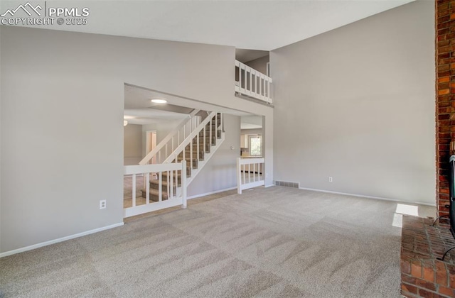 3177 Blue Mountain Way, Colorado Springs, CO 80906 - unfurnished living room featuring stairway, carpet floors, baseboards, and a towering ceiling