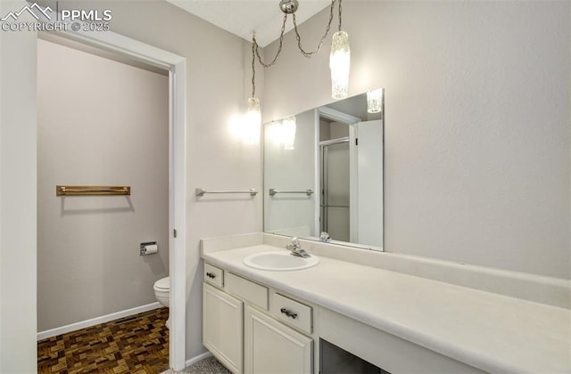 3177 Blue Mountain Way, Colorado Springs, CO 80906 - bathroom with toilet, vanity, baseboards, and a shower with shower door