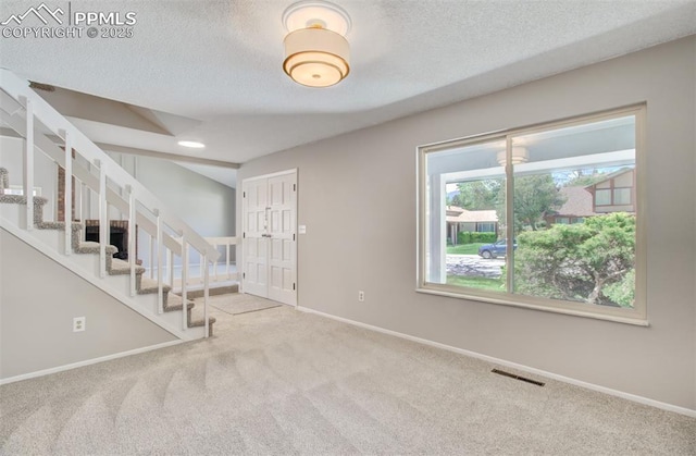 3177 Blue Mountain Way, Colorado Springs, CO 80906 - carpeted entrance foyer with baseboards, a textured ceiling, and stairway