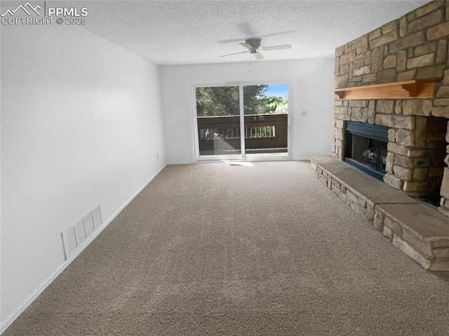 937 Moorings Dr, Colorado Springs, CO 80906 - unfurnished living room featuring a ceiling fan, carpet floors, a textured ceiling, a stone fireplace, and baseboards
